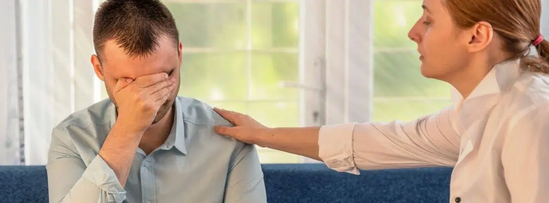 Image of a counselor consoling a patient holding hand over his face - Addiction Recovery Provide Safety
