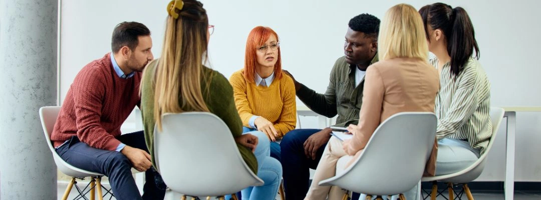 Image of men and women sitting in a circle at an Al Anon Meeting - Difference Between Al Anon and Nar Anon - Purpose Healing Center