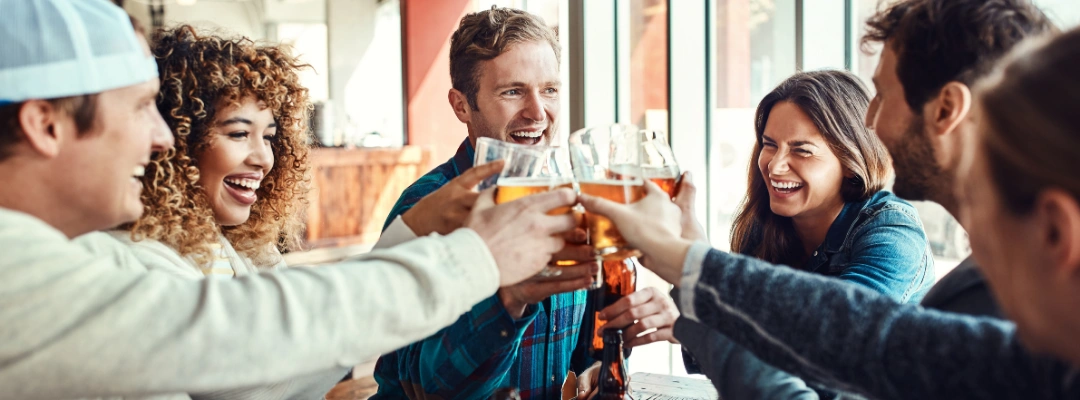 Image of a group of friends drinking non-alcoholic beer, highlighting the social risks and potential impact on liver recovery