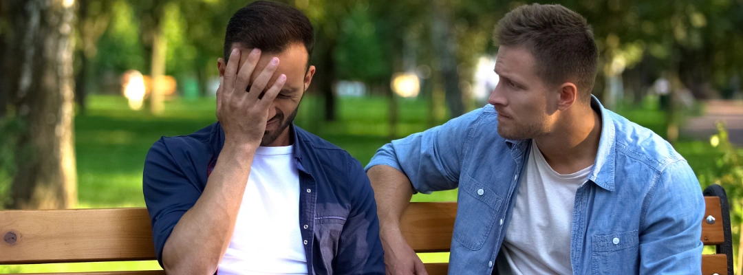 Image of an AA sponsor comforting and talking with a member struggling with cravings, representing guidance and support in managing addiction triggers