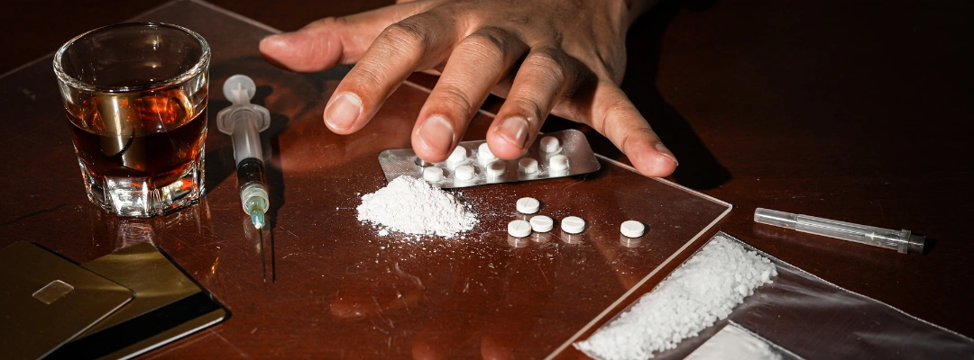Image of meth and white pills on a table representing the dangerous mix of opioids and stimulants known as a goofball