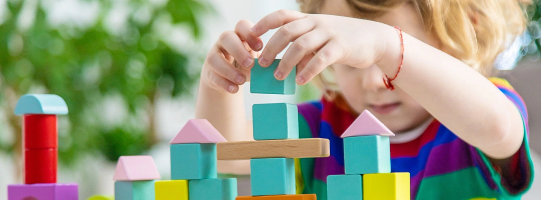 Child focusing on building blocks during a developmental learning activity