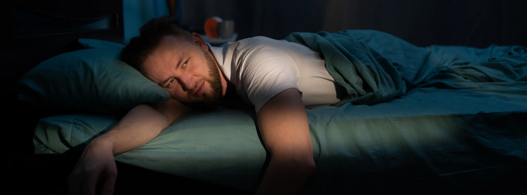 Image of a person lying in bed, wide-eyed and restless, struggling to sleep during the first hours of kratom withdrawal